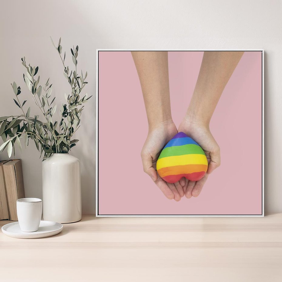 Obraz w ramie 80x80 - Miłość na Dłoniach - zdjęcie, dłonie trzymają ulepione tęczowe serce - rama biała