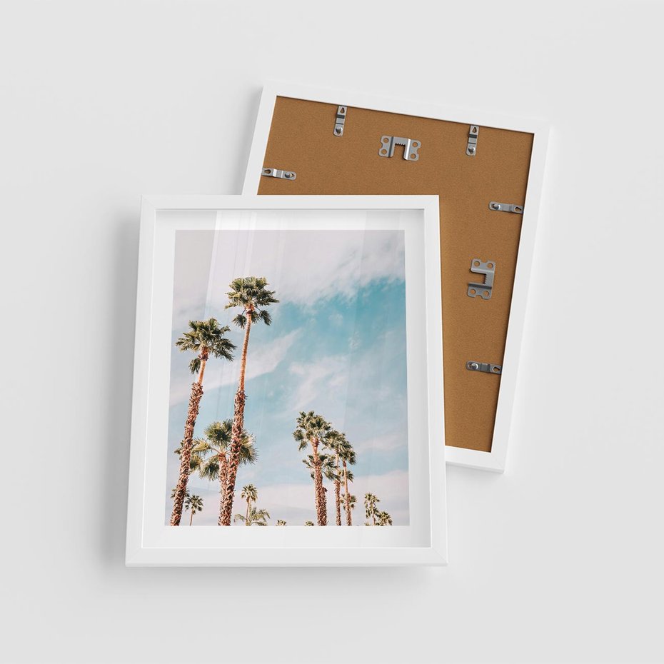 Plakat w ramie 40x50 - Tropikalna Sielskość: Palmy i Błękitne Niebo - palmy na tle błękitnego nieba - rama biała