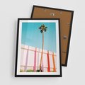 Plakat w ramie 50x70 - Tropikalny Kontrast - palma na tle błękitnego nieba, kolorowy mur - rama czarna