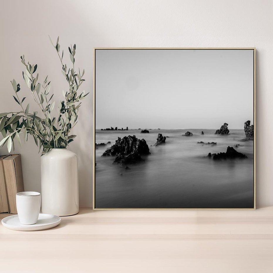 Obraz w ramie 50x50 - Harmonia świateł i cieni - zamglona dzika plaża, skały na plaży - rama drewno