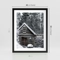 Plakat w ramie 40x50 - Zaklęta Zima - domek w lesie, śnieg - rama czarna