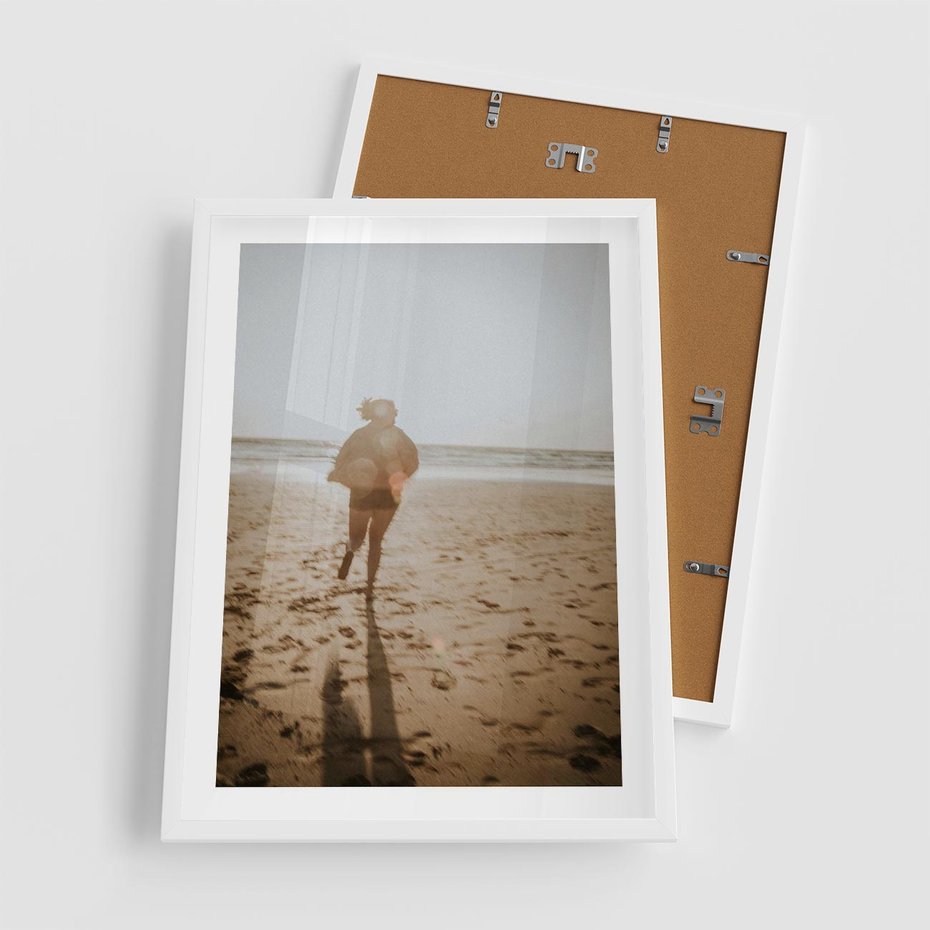 Plakat w ramie 50x70 - O Zachodzie Słońca - klimatyczna fotografia, postać biegnie po plaży - rama biała