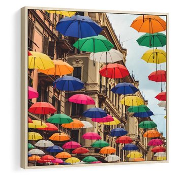 Obraz w ramie 80x80 - Barwna symfonia wyobraźni - fotografia, kolorowe parasolki podwieszone nad ulicą - rama drewno
