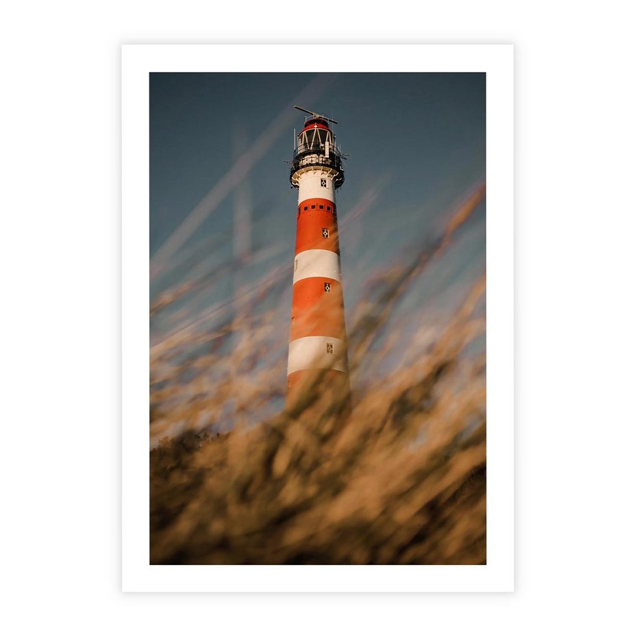 Plakat bez ramy 21x30 - Magia nadmorskiego światła - latarnia morska, ujęcie z za trawy