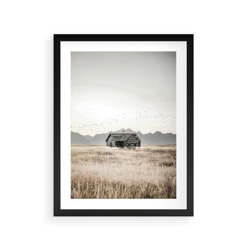 Plakat w ramie 50x70 - Wiejska Idylla - stary drewniany dom w polu suchej trawy, fotografia - rama czarna