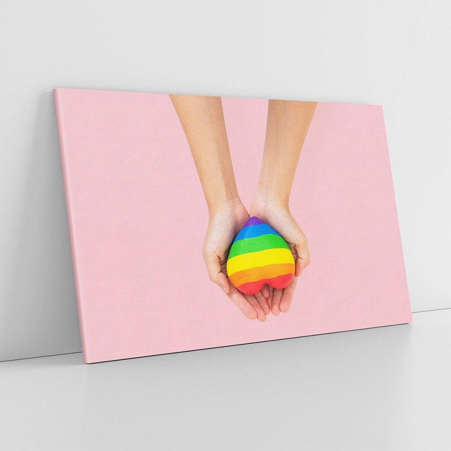 Obraz na płótnie 70x50 - Miłość na Dłoniach - zdjęcie, dłonie trzymają ulepione tęczowe serce