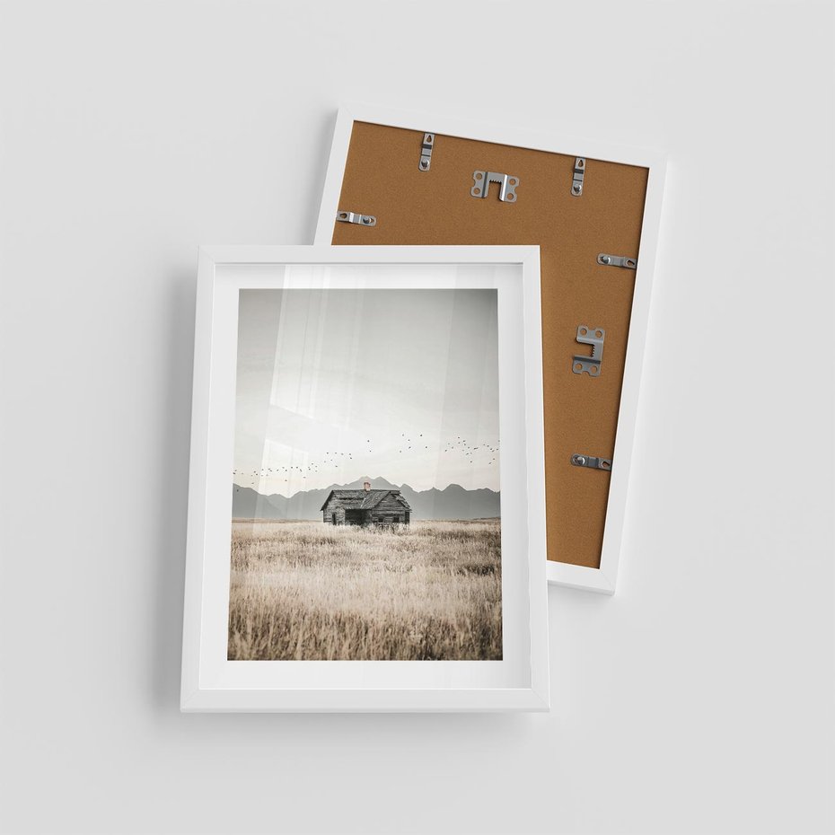 Plakat w ramie 30x40 - Wiejska Idylla - stary drewniany dom w polu suchej trawy, fotografia - rama biała
