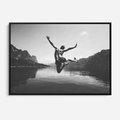Obraz w ramie 100x70 - Beztroska Chwila - czarno biała fotografia, mężczyzna wesoło wskakuje do keziora w górach - rama czarna