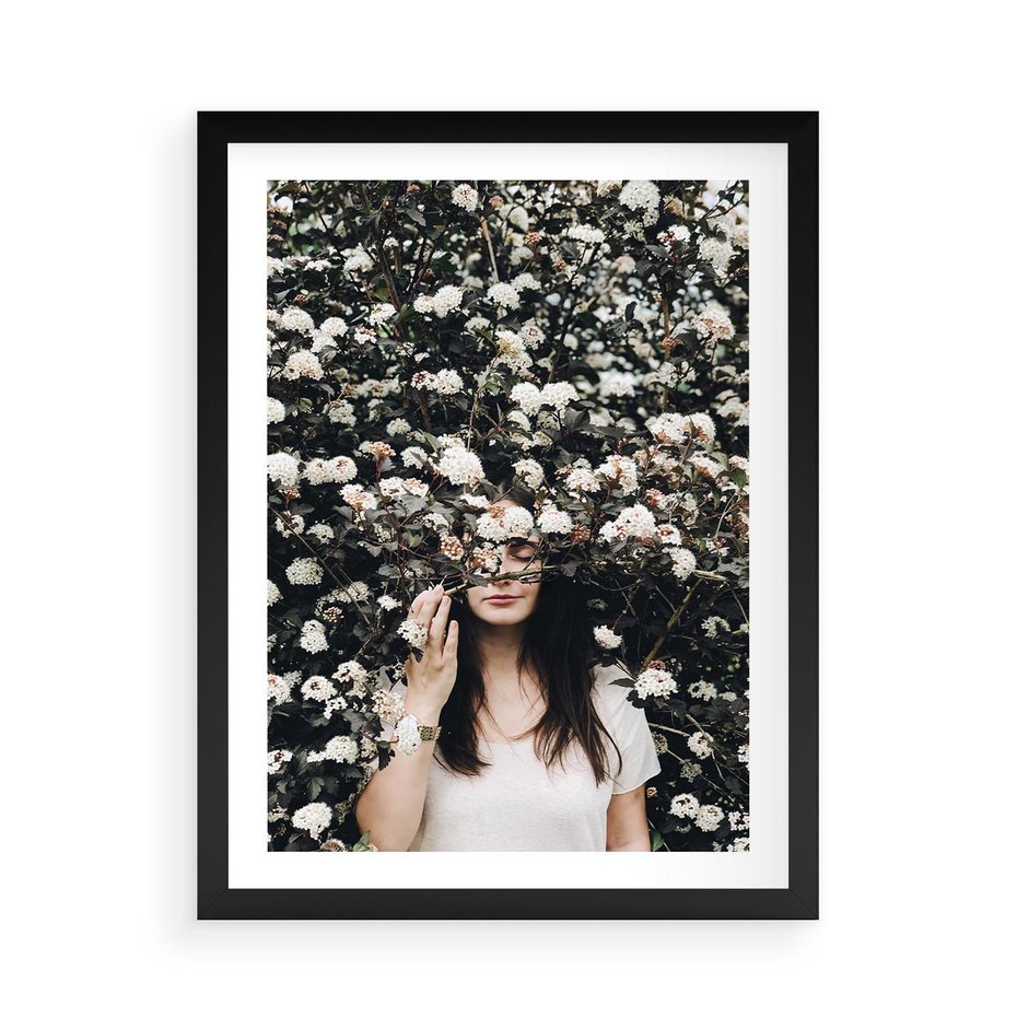 Plakat w ramie 50x70 - Kobieta w Krzewie Kwiatów - krzak z kwiatami, schowana za nim kobieta - rama czarna