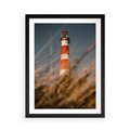 Plakat w ramie 50x70 - Magia nadmorskiego światła - latarnia morska, ujęcie z za trawy - rama czarna