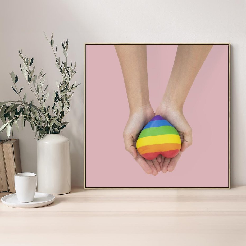 Obraz w ramie 80x80 - Miłość na Dłoniach - zdjęcie, dłonie trzymają ulepione tęczowe serce - rama drewno