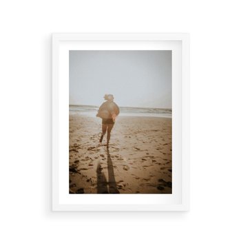 Plakat w ramie 40x50 - O Zachodzie Słońca - klimatyczna fotografia, postać biegnie po plaży - rama biała