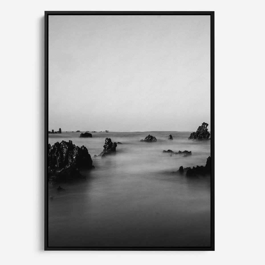 Obraz w ramie 50x70 - Harmonia świateł i cieni - zamglona dzika plaża, skały na plaży - rama czarna