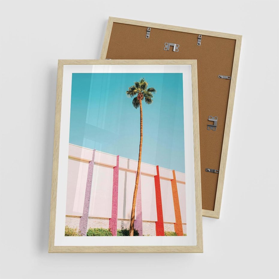 Plakat w ramie 50x70 - Tropikalny Kontrast - palma na tle błękitnego nieba, kolorowy mur - rama drewno