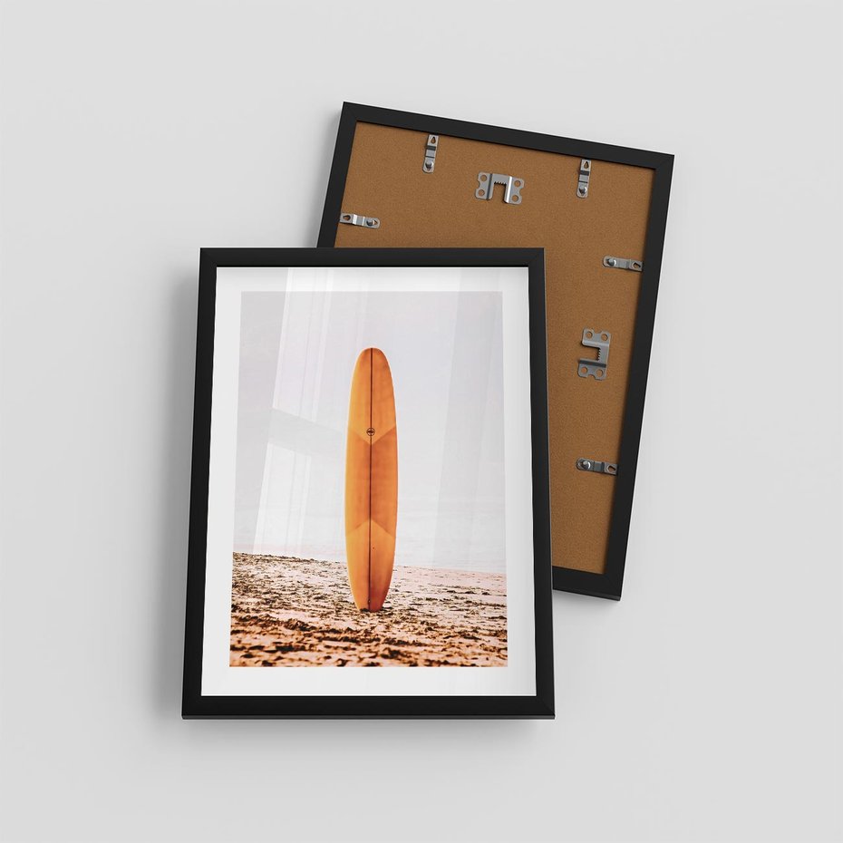 Plakat w ramie 30x40 - Deska w Piasku: Gotowa na Fale - plaża, pomarańczowa deska surfingowa wbita w piasek - rama czarna