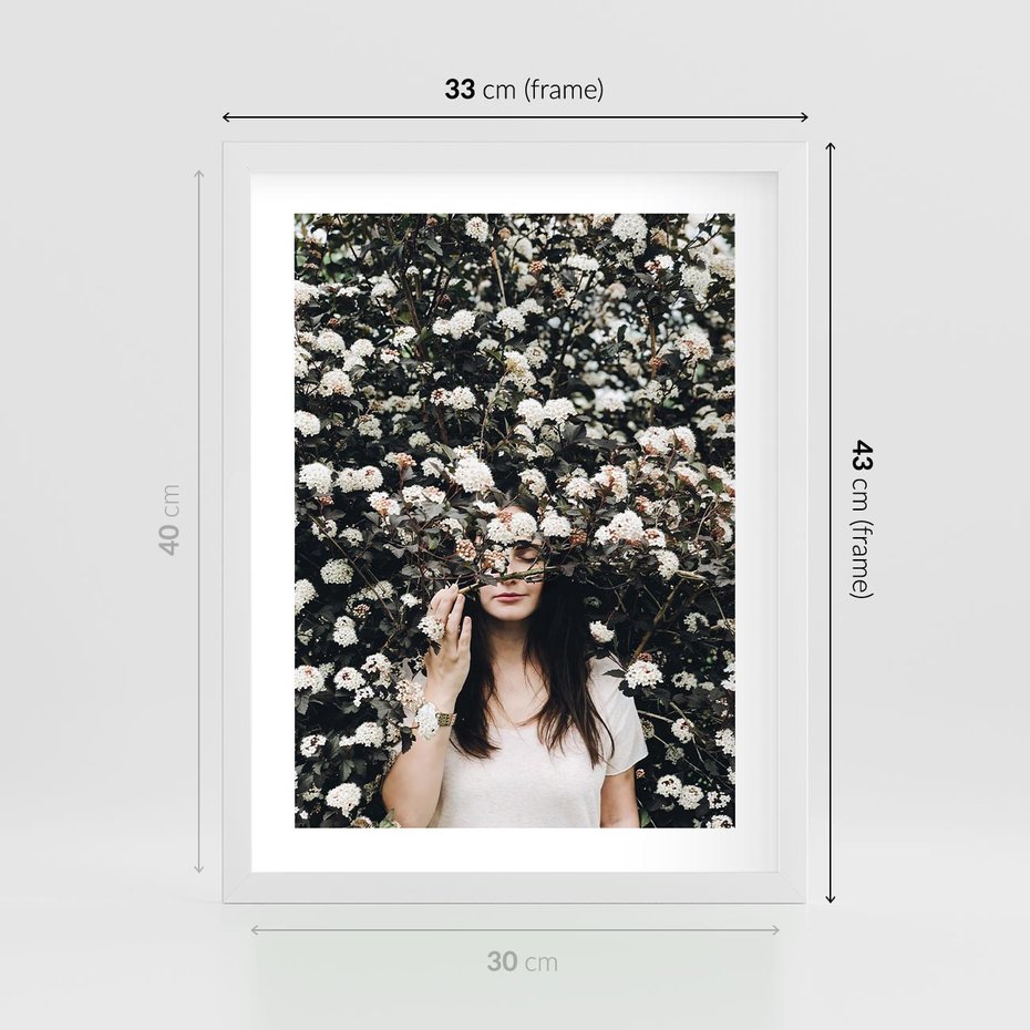 Plakat w ramie 30x40 - Kobieta w Krzewie Kwiatów - krzak z kwiatami, schowana za nim kobieta - rama biała