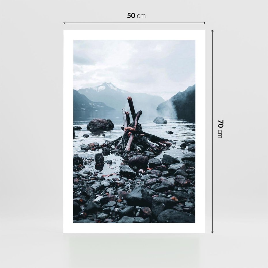 Plakat bez ramy 50x70 - To ujęcie jeziora w górach z zgaszonym ogniskiem nad brzegiem, tworząc atmosferę spokoju i refleksji w otoczeniu przyrody. - jezioro w górach, zgaszone ognisko