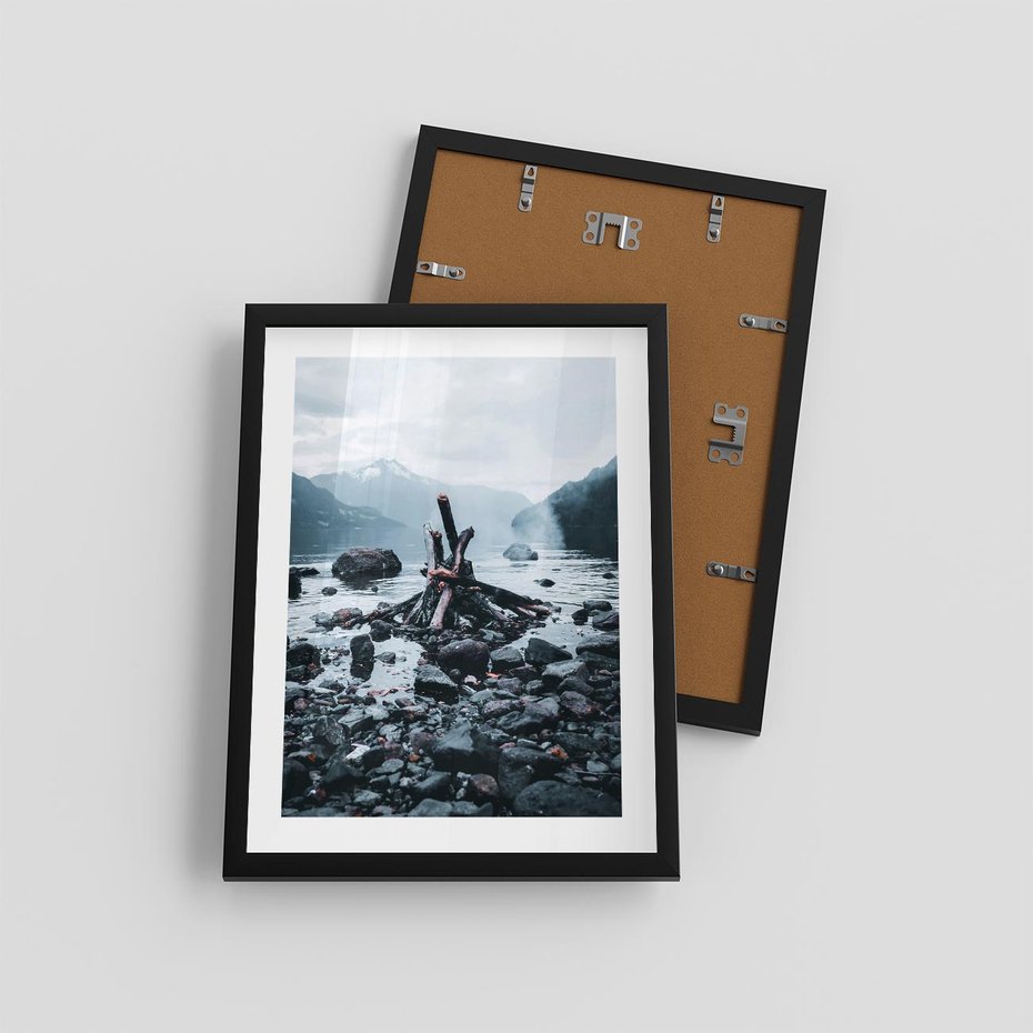 Plakat w ramie 30x40 - To ujęcie jeziora w górach z zgaszonym ogniskiem nad brzegiem, tworząc atmosferę spokoju i refleksji w otoczeniu przyrody. - jezioro w górach, zgaszone ognisko - rama czarna