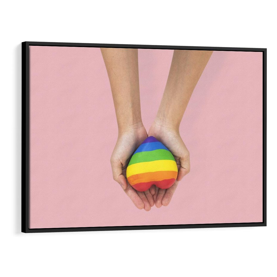 Obraz w ramie 100x70 - Miłość na Dłoniach - zdjęcie, dłonie trzymają ulepione tęczowe serce - rama czarna