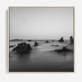 Obraz w ramie 50x50 - Harmonia świateł i cieni - zamglona dzika plaża, skały na plaży - rama drewno