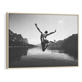 Obraz w ramie 70x50 - Beztroska Chwila - czarno biała fotografia, mężczyzna wesoło wskakuje do keziora w górach - rama drewno