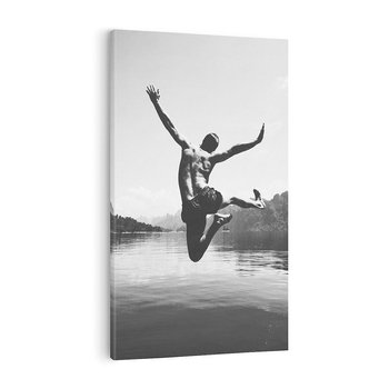 Obraz na płótnie 80x120 - Beztroska Chwila - czarno biała fotografia, mężczyzna wesoło wskakuje do keziora w górach