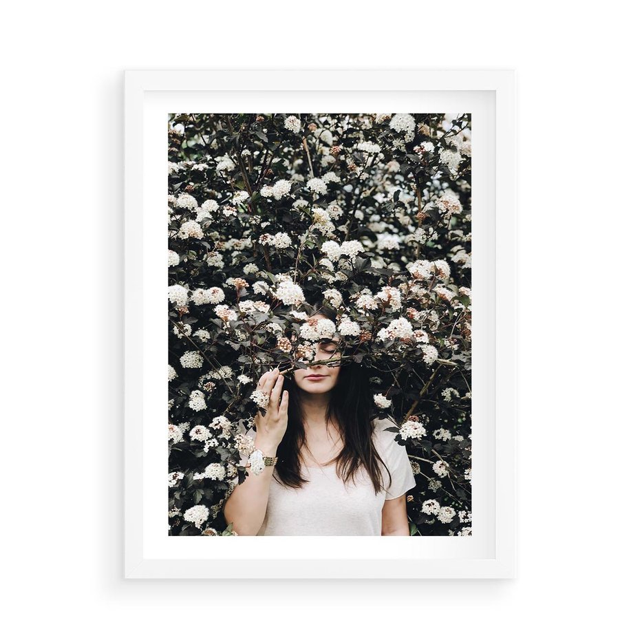 Plakat w ramie 50x70 - Kobieta w Krzewie Kwiatów - krzak z kwiatami, schowana za nim kobieta - rama biała