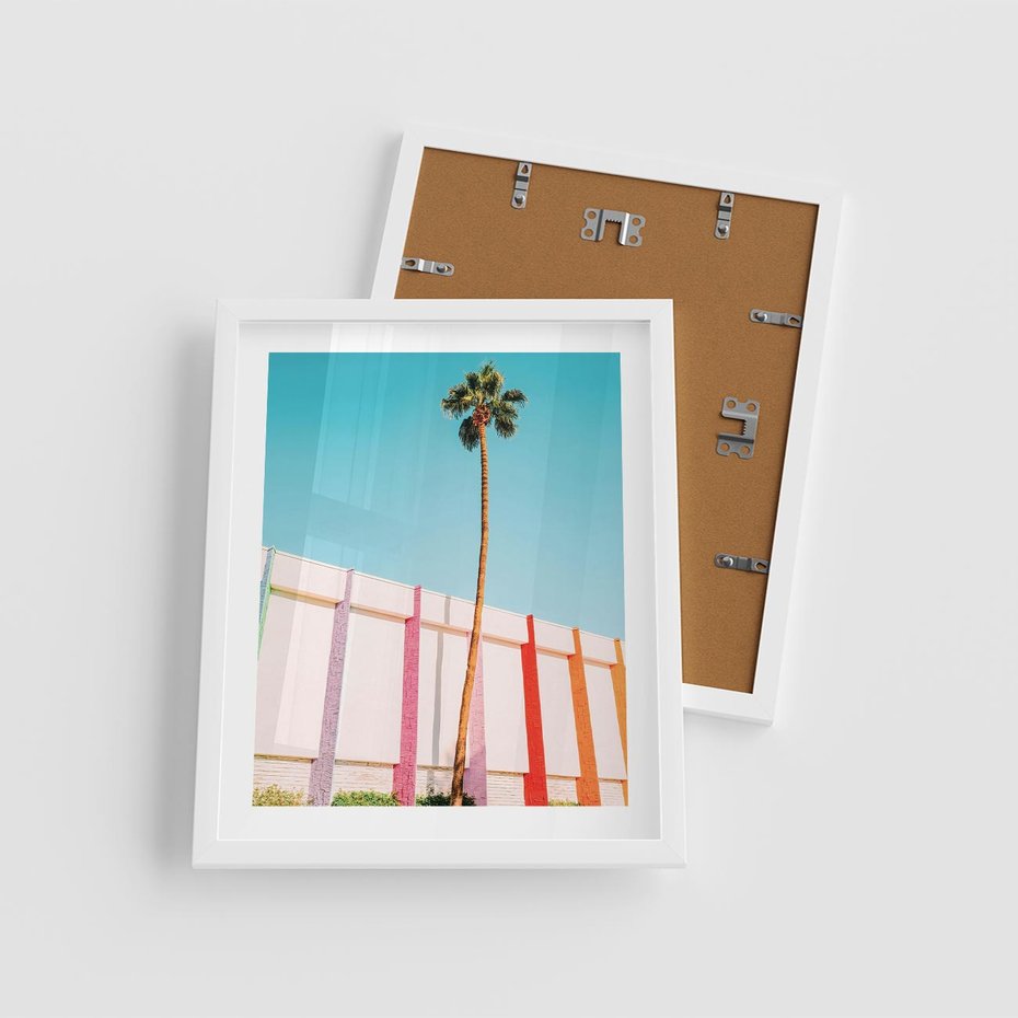 Plakat w ramie 40x50 - Tropikalny Kontrast - palma na tle błękitnego nieba, kolorowy mur - rama biała