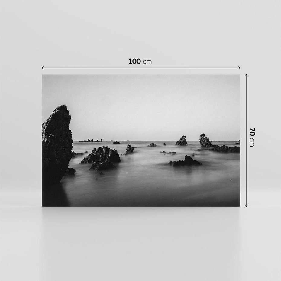 Obraz na płótnie 100x70 - Harmonia świateł i cieni - zamglona dzika plaża, skały na plaży