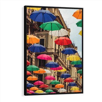Obraz w ramie 70x100 - Barwna symfonia wyobraźni - fotografia, kolorowe parasolki podwieszone nad ulicą - rama czarna