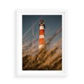 Plakat w ramie 50x70 - Magia nadmorskiego światła - latarnia morska, ujęcie z za trawy - rama biała
