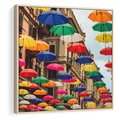Obraz w ramie 50x50 - Barwna symfonia wyobraźni - fotografia, kolorowe parasolki podwieszone nad ulicą - rama drewno