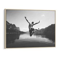 Obraz w ramie 100x70 - Beztroska Chwila - czarno biała fotografia, mężczyzna wesoło wskakuje do keziora w górach - rama drewno