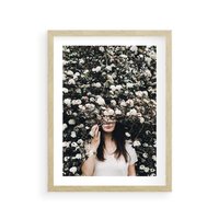 Plakat w ramie 50x70 - Kobieta w Krzewie Kwiatów - krzak z kwiatami, schowana za nim kobieta - rama drewno