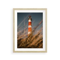 Plakat w ramie 30x40 - Magia nadmorskiego światła - latarnia morska, ujęcie z za trawy - rama drewno