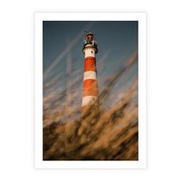 Plakat bez ramy 21x30 - Magia nadmorskiego światła - latarnia morska, ujęcie z za trawy