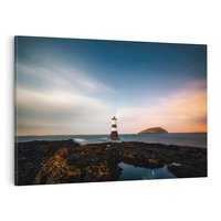 Obraz na płótnie 70x50 - Zachód słońca nad morzem: Magia plażowej scenerii - latarnia morska, morze
